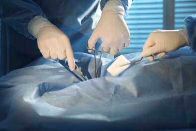 Professional surgeons with instruments performing operation in clinic, closeup