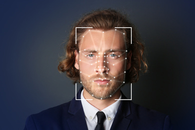 Facial recognition system. Businessman with scanner frame and digital biometric grid on dark background