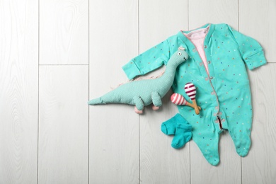 Stylish baby clothes and toys on wooden background, top view. Space for text