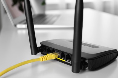 Connected cable to router on white table, closeup. Wireless internet communication