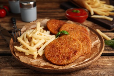 Delicious fried breaded cutlets served on wooden table