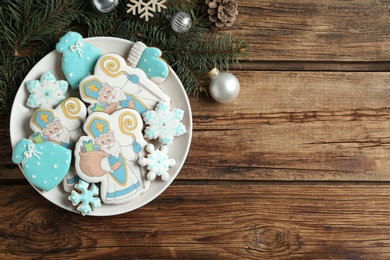 Tasty gingerbread cookies and festive decor on wooden table, flat lay with space for text. St. Nicholas Day celebration