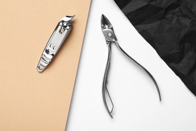 Photo of Nail clippers and cuticle nipper on color background, flat lay. Manicure tools