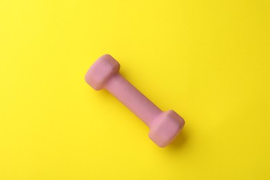 Stylish dumbbell on yellow background, top view
