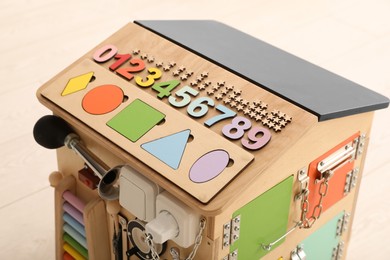 Busy board house indoors, closeup. Baby sensory toy