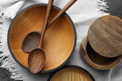 Stylish wooden dishware and spoons on grey table, flat lay