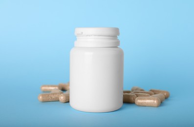 Gelatin capsules and bottle on light blue background