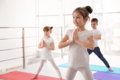 Little children practicing yoga in gym