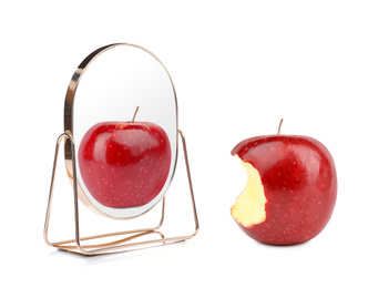 Bitten red apple and mirror with reflection on white background