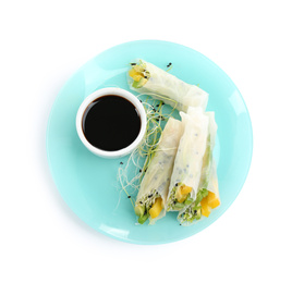 Delicious rolls wrapped in rice paper and soy sauce on white background, top view