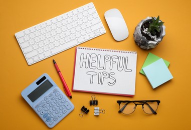 Photo of Helpful Tips. Flat lay composition with notebook, calculator and computer keyboard on orange background