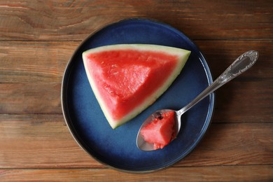 Sliced fresh juicy watermelon and spoon on wooden table, top view