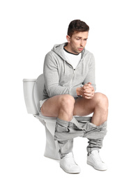Emotional man sitting on toilet bowl, white background