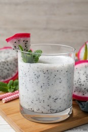 Glass of tasty pitahaya smoothie with fresh mint on white wooden table, closeup
