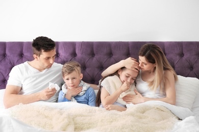 Family suffering from cold in bed at home