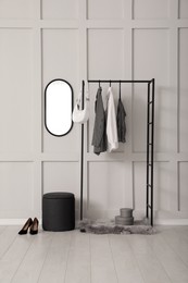 Simple hallway interior with clothing rack and mirror