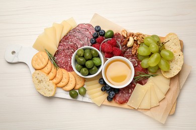 Snack set with delicious Parmesan cheese on light wooden table, top view