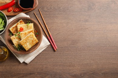 Delicious turnip cake with microgreens served on wooden table, flat lay. Space for text