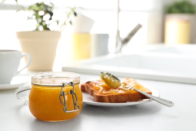 Delicious orange marmalade and toasts on white table. Space for text