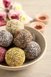 Photo of Different delicious vegan candy balls on white wooden table