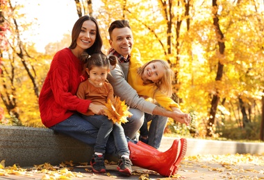 Photo of Happy family with little daughters in park. Autumn walk
