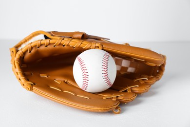 Photo of Catcher's mitt and baseball ball on white background. Sports game