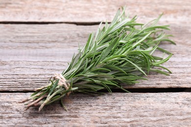 Bunch of fresh rosemary on wooden table, closeup