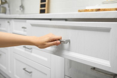Photo of Woman opening drawer in kitchen, closeup view