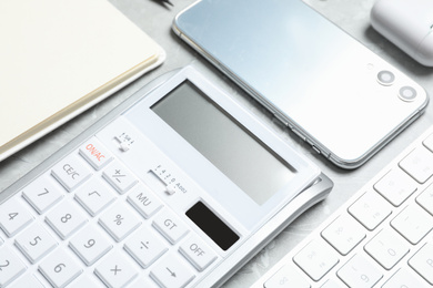 Calculator, smartphone and keyboard on grey table, closeup. Tax accounting