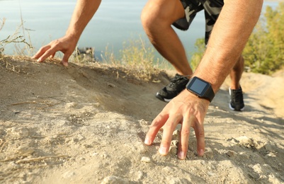 Man wearing modern smart watch during training outdoors, closeup