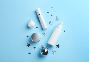 Flat lay composition with different cosmetic products on light blue background. Winter care
