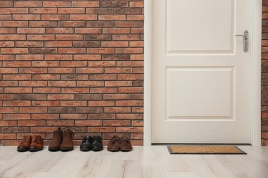 Different shoes near red brick wall in hallway