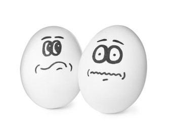 Photo of Eggs with drawn thoughtful and frightened faces on white background
