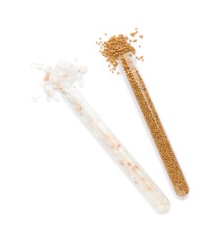 Glass tubes with pink himalayan salt and mustard seeds on white background, top view