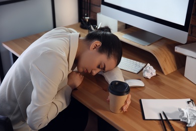 Stressed and tired young woman sleeping at workplace