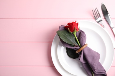 Romantic table setting on pink wooden background, flat lay with space for text. Valentine's day celebration