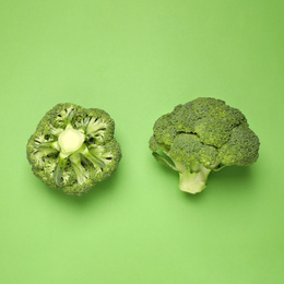 Fresh broccoli on green background, top view