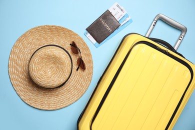 Flat lay composition with passport, tickets and travel items on light blue background