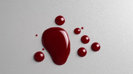 Photo of Drops of blood on grey background, top view