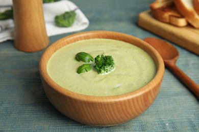 Delicious broccoli cream soup served on blue wooden table