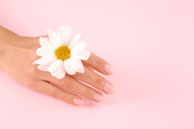 Closeup view of woman with flower on color background, space for text. Spa treatment