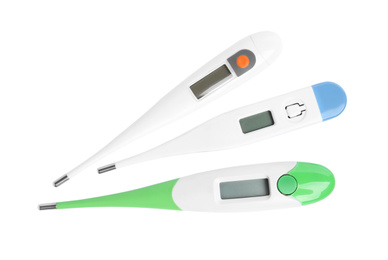 Modern digital thermometers on white background, top view