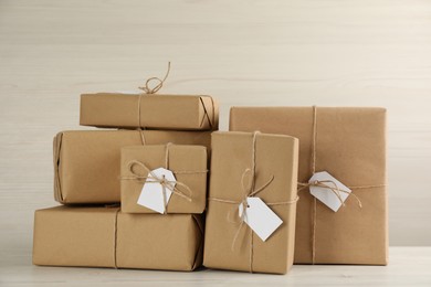 Parcels wrapped in kraft paper with tags on white wooden table
