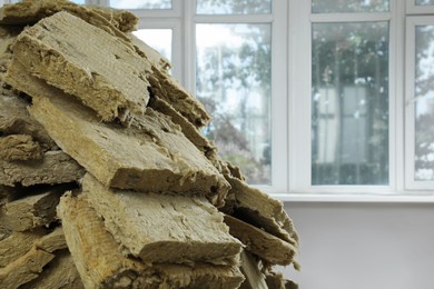 Photo of Heap of thermal insulation material in room, closeup. Space for text