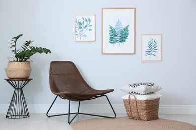 Photo of Comfortable armchair and plant near white wall indoors at home. Idea for interior design