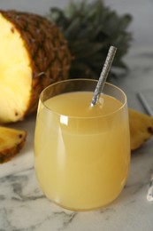 Photo of Delicious fresh pineapple juice on white marble table