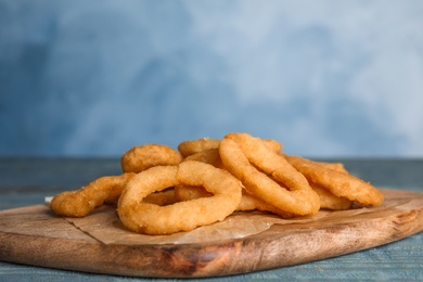 Fried onion rings served on blue wooden table