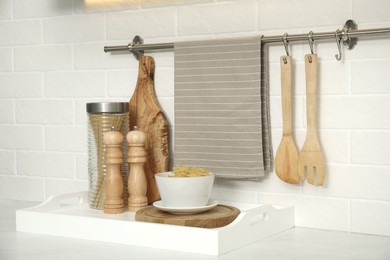 Clean towel, utensils and uncooked pasta in kitchen