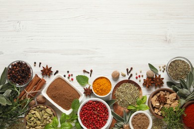 Different fresh herbs and spices on white wooden table, flat lay. Space for text