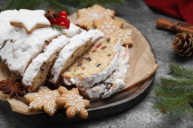 Traditional Christmas Stollen with icing sugar on grey table